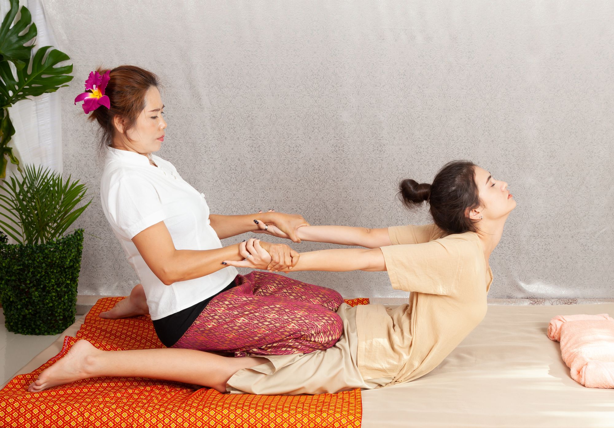 Massage therapist stretching the back of a patient in a traditional massage pose